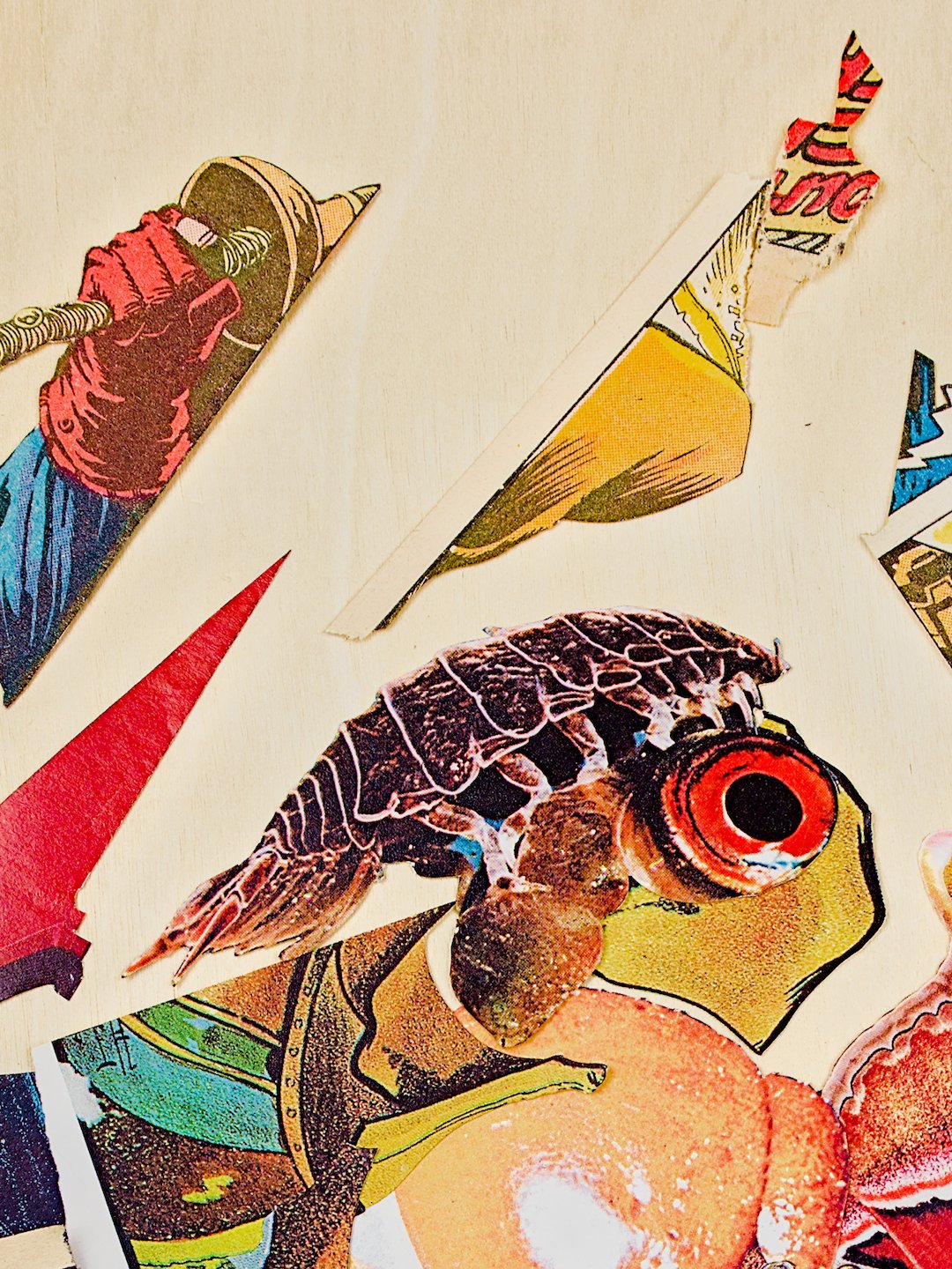 A detail of the upper middle of the work, showing isopod-like plates and legs on top of a bright-red fish eye. Clippings above this form strong diagonal lines in the negative space. Among them is the raised red fist clutching the handle of a sword.
